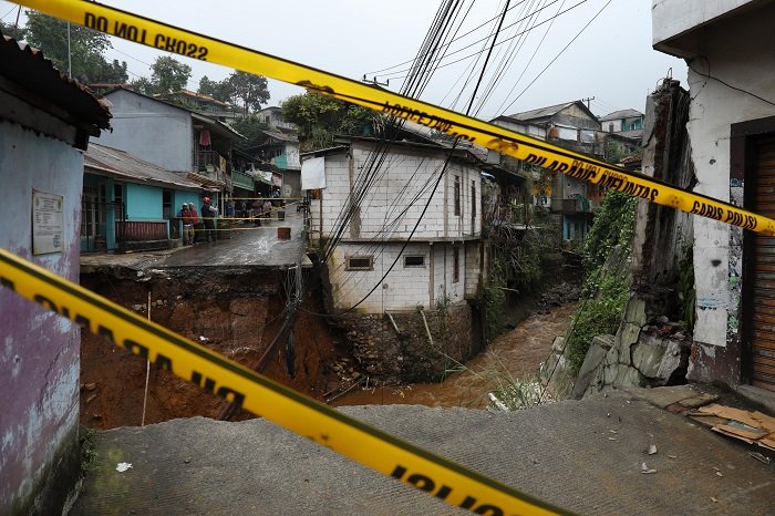 Sejumlah warga beraktivitas di dekat lokasi jembatan yang amblas terdampak banjir bandang di Desa Tugu Selatan, Kecamatan Cisarua, Kabupaten Bogor, Jawa Barat, Senin (3/3/2025). (Dok. BNPB)